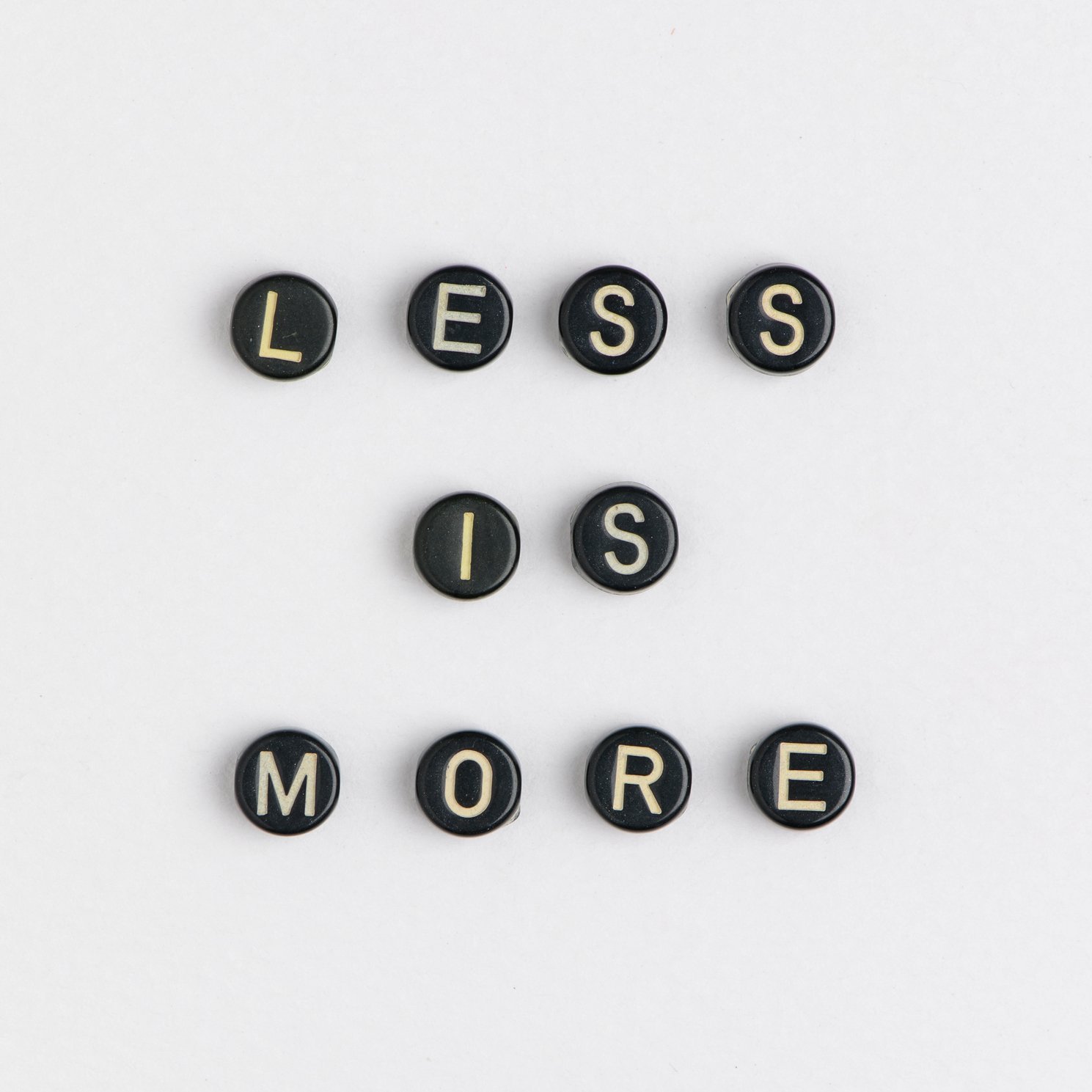 Letter beads spelling 'less is more'